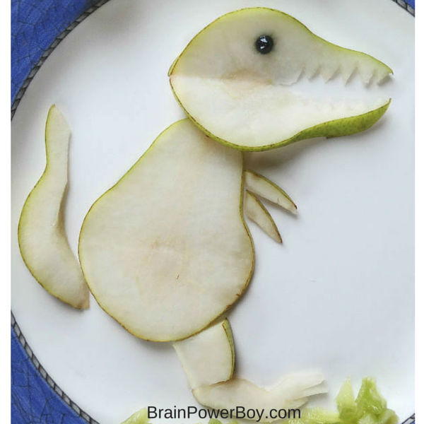 Closeup of our fun food dinosaur made out of a pear. This is an easy to make dinosaur snack for kids!