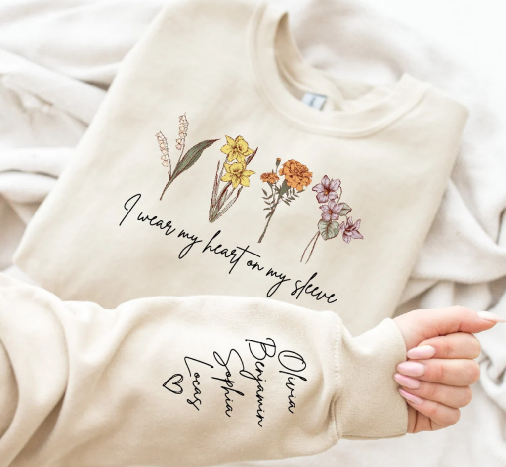 sweatshirt with saying I wear my heart on my sleeve and children's names and their birth flowers.
