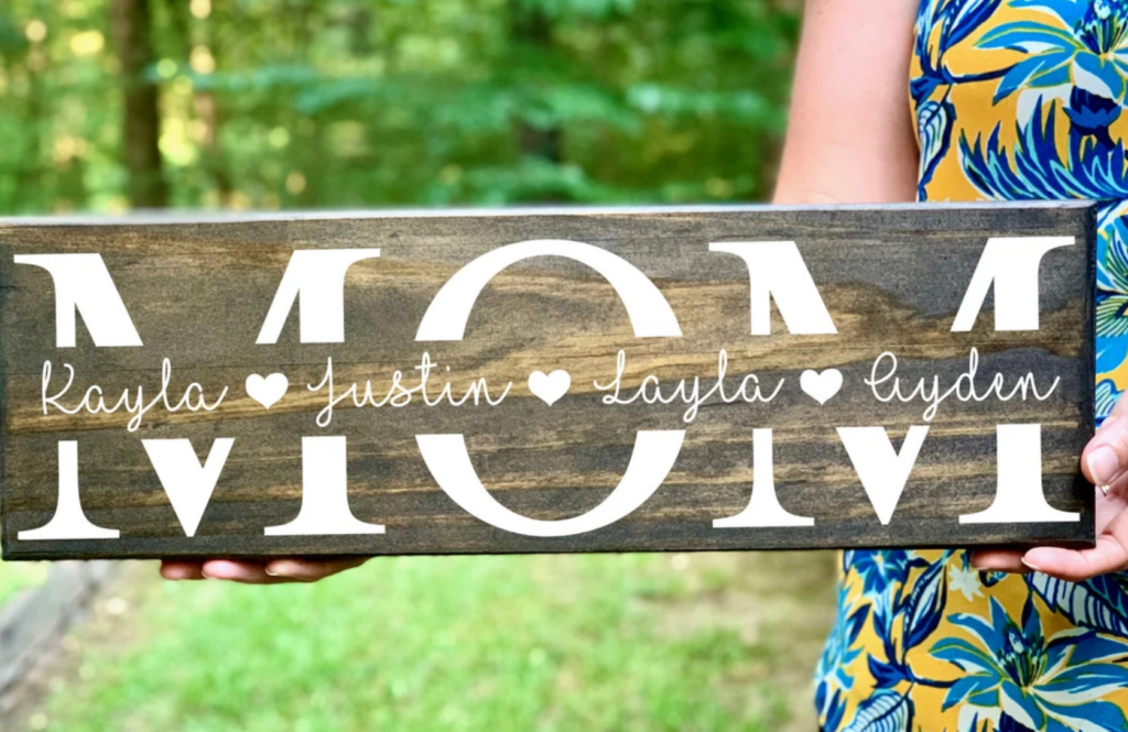 wooden sign with the word mom and children's names in script across the word mom
